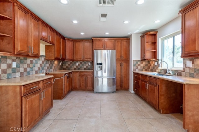 kitchen featuring light tile patterned floors, tasteful backsplash, stainless steel fridge with ice dispenser, and sink