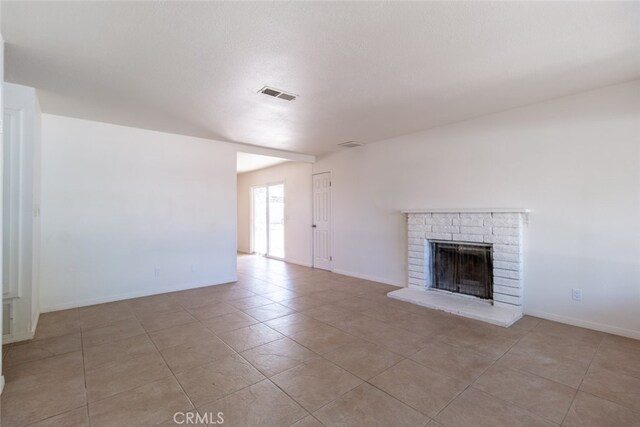 unfurnished living room with a fireplace and light tile patterned floors