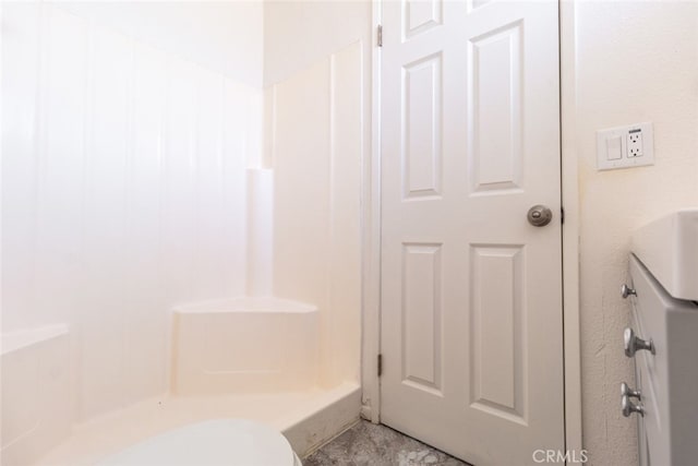 bathroom featuring walk in shower and toilet