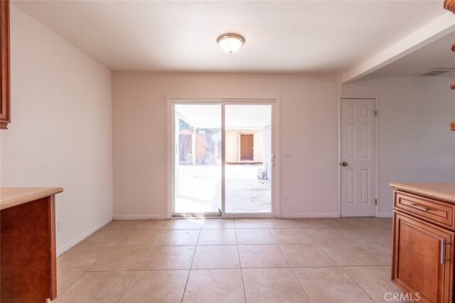 unfurnished dining area with light tile patterned flooring