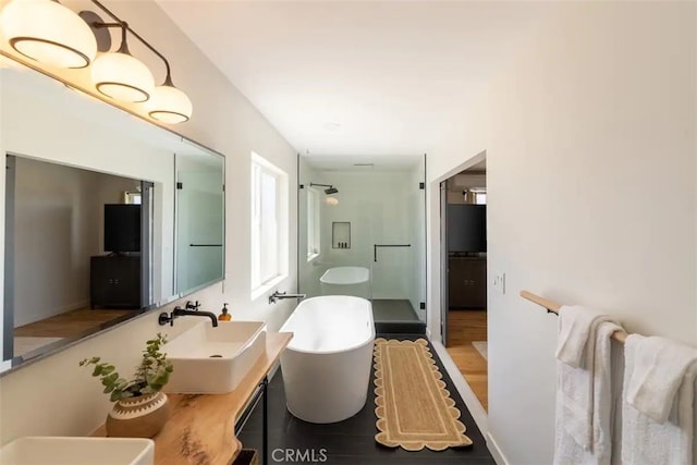 bathroom featuring vanity, hardwood / wood-style floors, and plus walk in shower