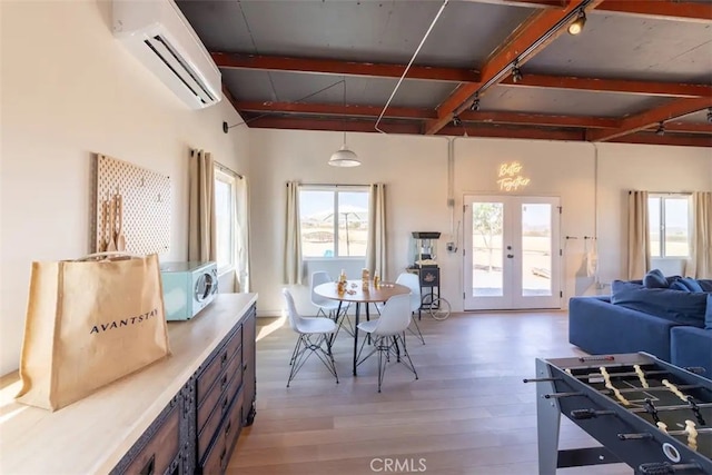 dining room featuring a wall mounted air conditioner, french doors, and light wood-type flooring