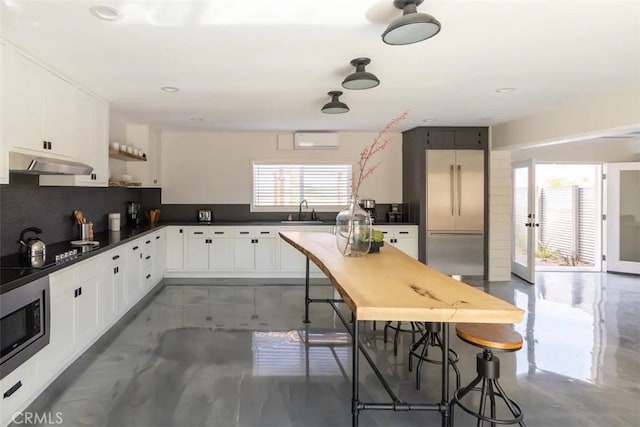 kitchen with sink, backsplash, stainless steel appliances, white cabinets, and a wall mounted AC