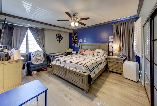 bedroom with light hardwood / wood-style flooring, ceiling fan, and ornamental molding