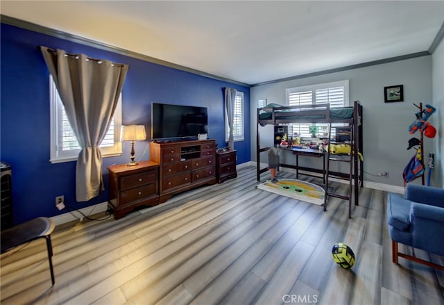 bedroom with ornamental molding and light hardwood / wood-style floors