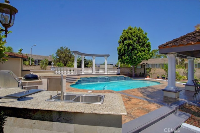 view of swimming pool featuring area for grilling, a patio area, and sink