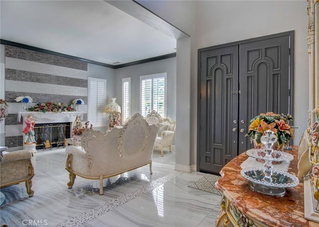 living room featuring a high end fireplace and crown molding