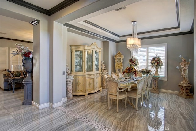 dining space featuring a notable chandelier, a raised ceiling, and crown molding