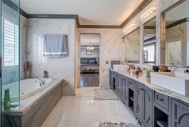 bathroom with tile walls, a notable chandelier, crown molding, tiled bath, and vanity