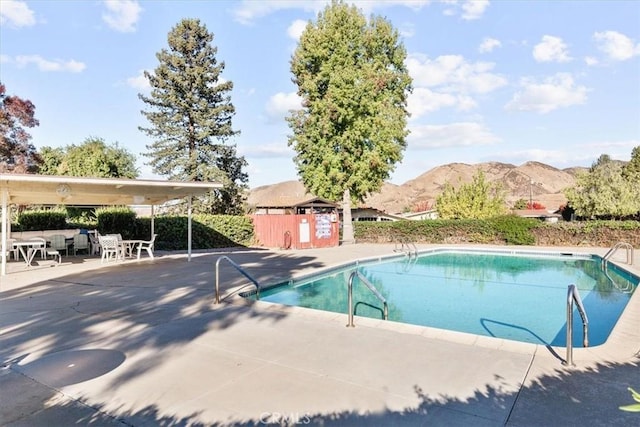 view of swimming pool featuring a mountain view and a patio