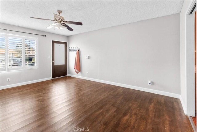 interior space featuring dark hardwood / wood-style flooring, a textured ceiling, and ceiling fan