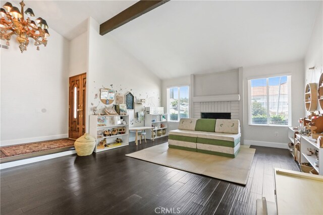 interior space featuring beamed ceiling, dark wood-type flooring, high vaulted ceiling, and a healthy amount of sunlight