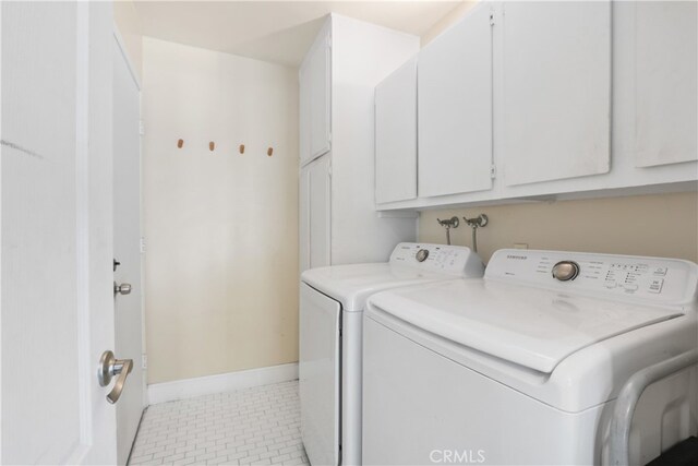 washroom featuring cabinets, light tile patterned floors, and washing machine and dryer