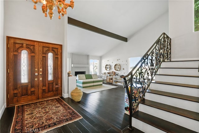 foyer with beamed ceiling, a chandelier, high vaulted ceiling, hardwood / wood-style flooring, and a fireplace