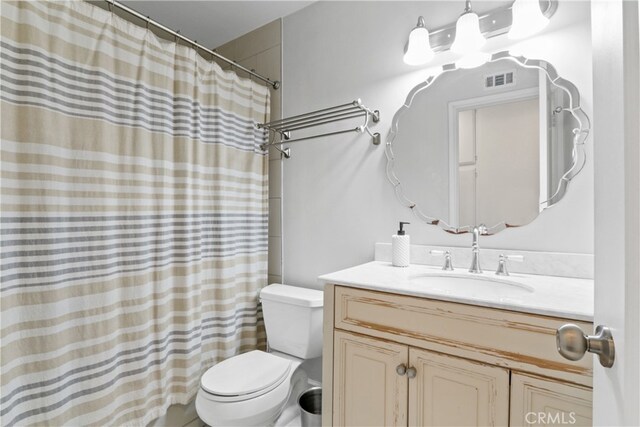 bathroom featuring a shower with curtain, vanity, and toilet