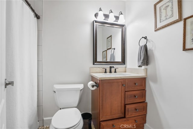 bathroom with walk in shower, vanity, and toilet