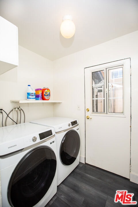 washroom with dark hardwood / wood-style flooring and washing machine and clothes dryer