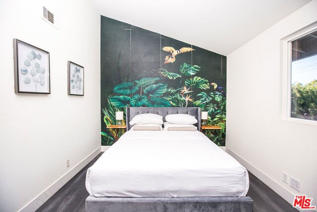 bedroom featuring dark hardwood / wood-style flooring and lofted ceiling