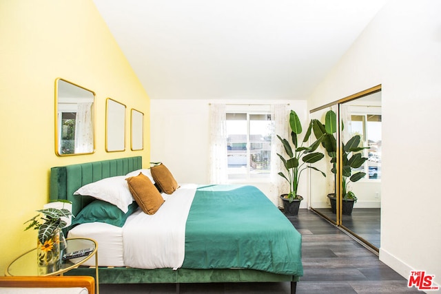 bedroom featuring a closet, dark wood-type flooring, and lofted ceiling