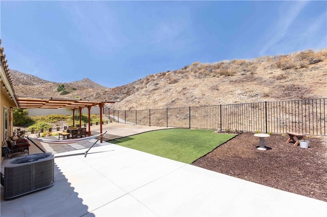 view of patio / terrace with a pergola, a mountain view, and central AC unit