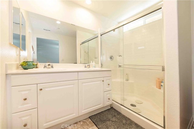 bathroom featuring walk in shower and vanity