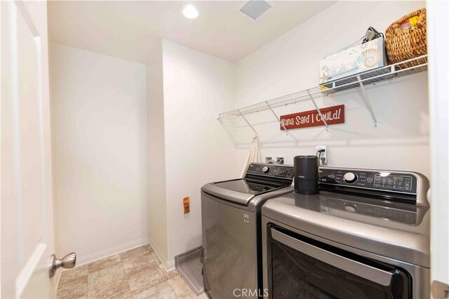 clothes washing area with washer and clothes dryer