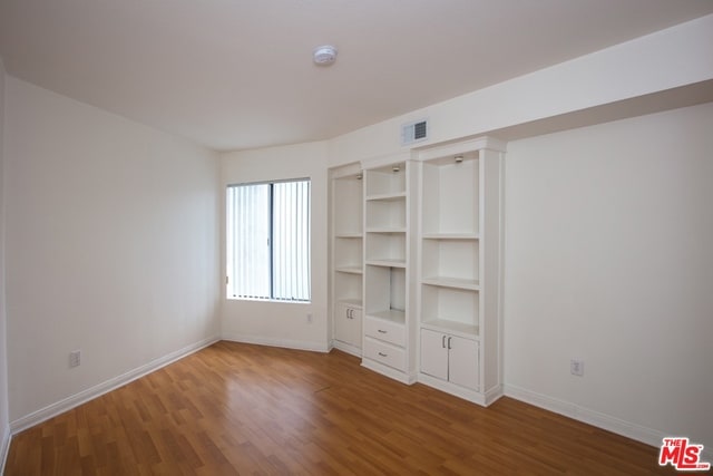 unfurnished bedroom with dark wood-type flooring