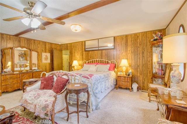 bedroom with light colored carpet, wooden walls, beam ceiling, and a textured ceiling