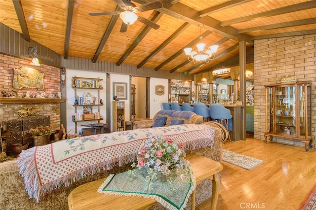 bedroom with hardwood / wood-style floors, vaulted ceiling with beams, wood ceiling, a brick fireplace, and an inviting chandelier