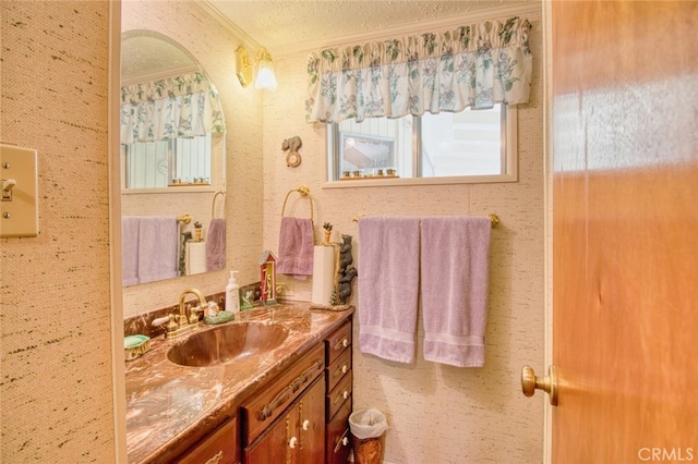 bathroom featuring vanity, crown molding, and a textured ceiling