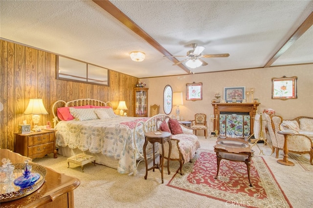 carpeted bedroom featuring ceiling fan, wooden walls, and a textured ceiling