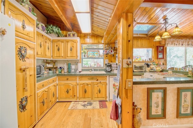 kitchen featuring vaulted ceiling with skylight, sink, a wealth of natural light, and wood ceiling