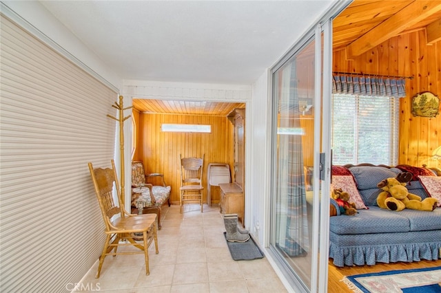 sitting room with wooden walls and light tile patterned floors