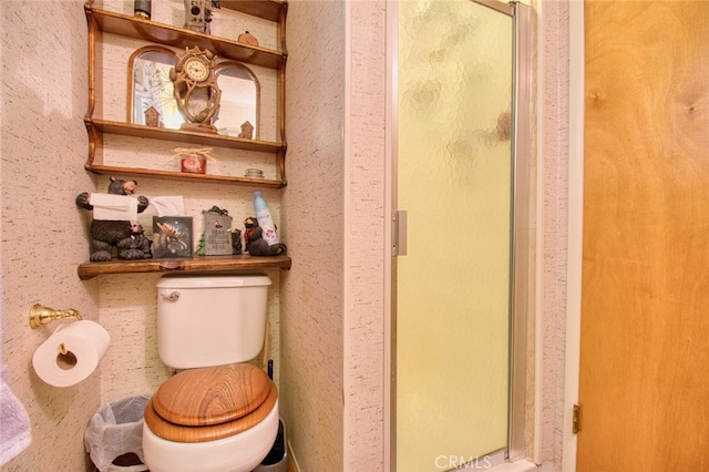 bathroom featuring an enclosed shower and toilet