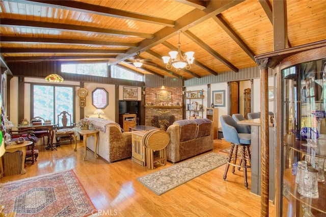 living room with vaulted ceiling with beams, wood ceiling, a chandelier, and light wood-type flooring