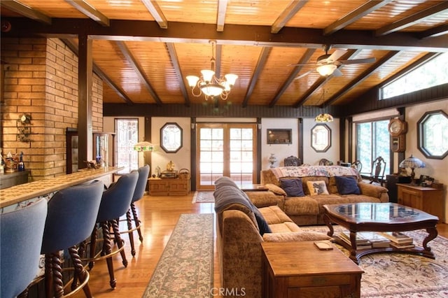 living room featuring wood ceiling, ceiling fan with notable chandelier, light hardwood / wood-style floors, and vaulted ceiling with beams