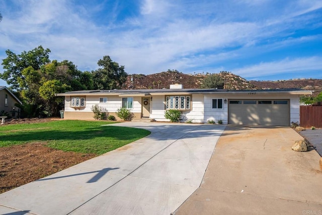 ranch-style house featuring a garage and a front lawn