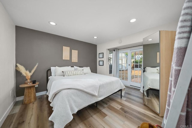 bedroom featuring access to exterior, hardwood / wood-style floors, and french doors