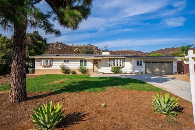 ranch-style house with a front yard, a mountain view, and a garage