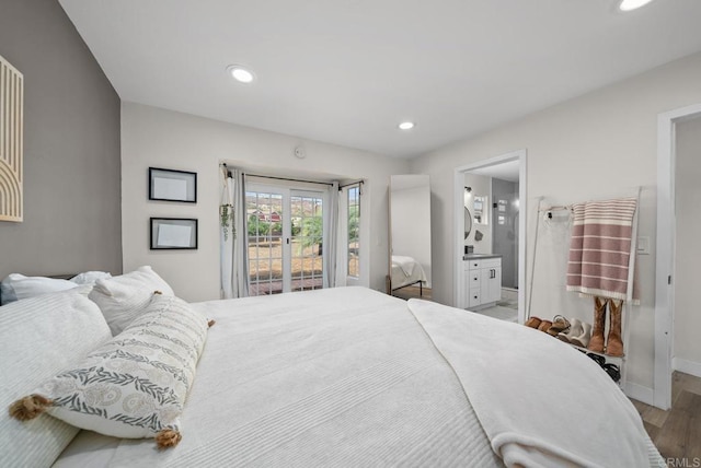 bedroom with hardwood / wood-style floors and ensuite bath