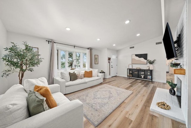 living room with light hardwood / wood-style floors and lofted ceiling