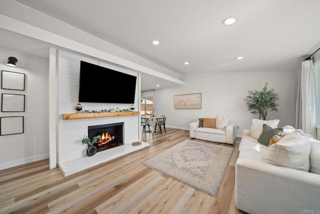 living room featuring a brick fireplace, hardwood / wood-style flooring, and vaulted ceiling