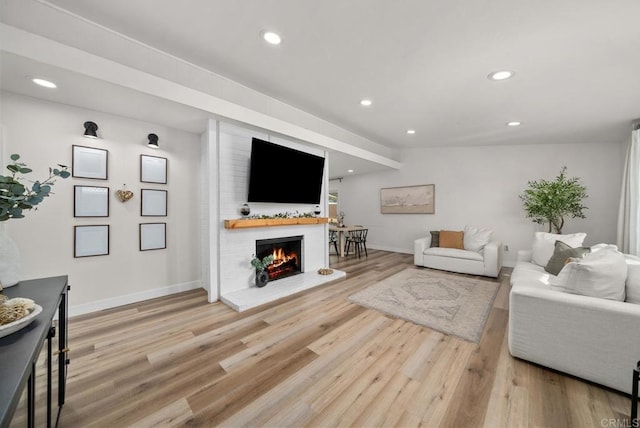 living room featuring hardwood / wood-style flooring, lofted ceiling, and a fireplace