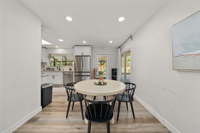 dining area with sink and light hardwood / wood-style flooring