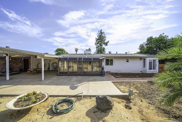 rear view of house with a sunroom and a patio