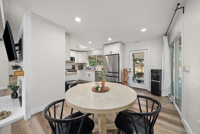 dining area featuring light wood-type flooring and sink