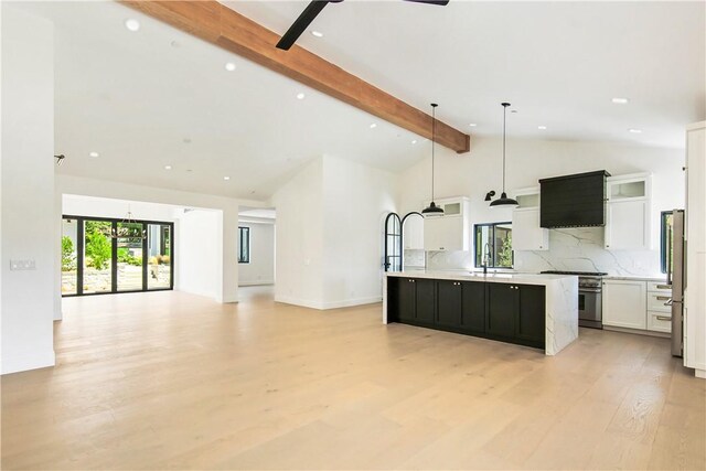 kitchen featuring beam ceiling, a large island, white cabinetry, hanging light fixtures, and light wood-type flooring