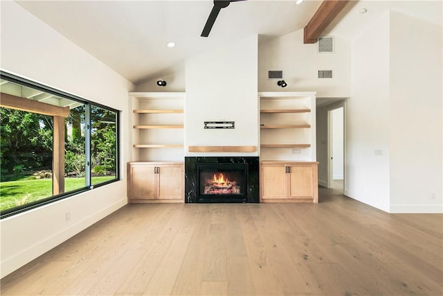 unfurnished living room with ceiling fan, a premium fireplace, beamed ceiling, high vaulted ceiling, and light hardwood / wood-style floors