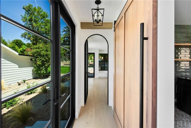 hallway with a chandelier and light hardwood / wood-style flooring