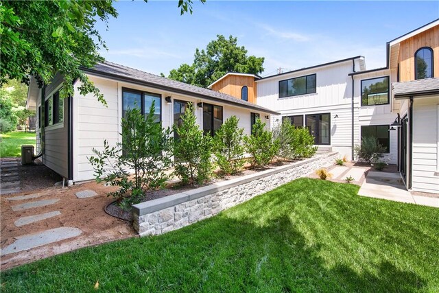 rear view of house with a yard and central AC unit